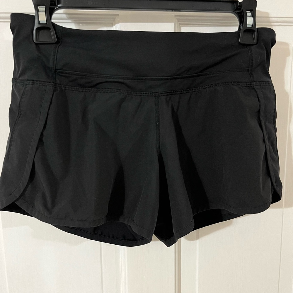 Size 4 Lululemon 4” hotty hot shorts. Older shorts in GUC. Logo faded some.